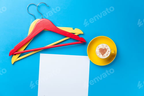 Preview: paper, cup and hangers lying on the table
