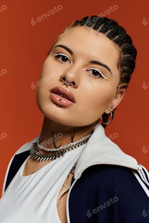Preview: Stylish young woman with braided hair posing against a vibrant orange backdrop