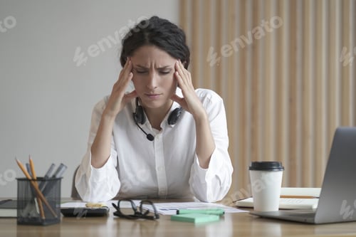 Preview: Stressed entrepreneur lady suffering from headache massaging temples while sitting at home office
