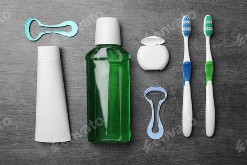 Preview: Flat lay composition with tongue cleaners and teeth care products on grey background