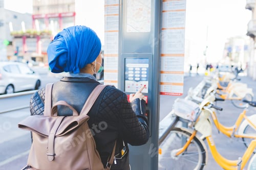 Preview: arabian young woman outdoor booking bike sharing