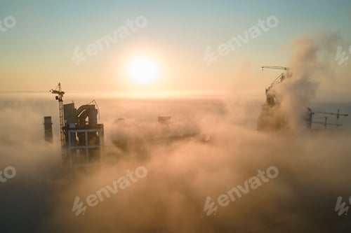 Preview: Aerial view of cement factory with high concrete plant structure and tower crane at industrial