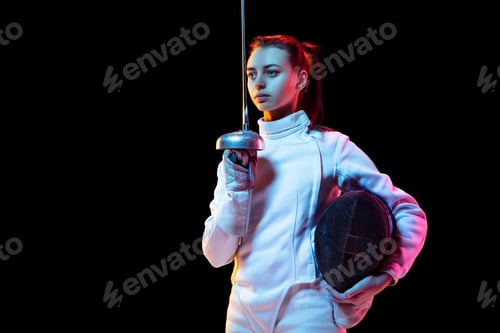 Preview: Teen girl in fencing costume with sword in hand isolated on black background