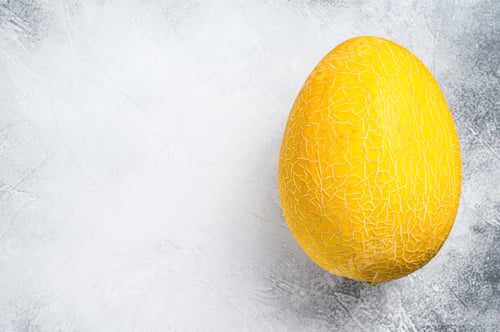 Preview: Whole yellow ripe melon. White background. Top view. Copy space