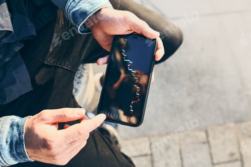 Preview: Man investing trading on stock cryptocurrency market using investing application on smartphone