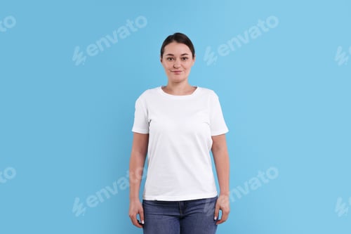 Preview: Woman in white t-shirt on light blue background. Mockup for design