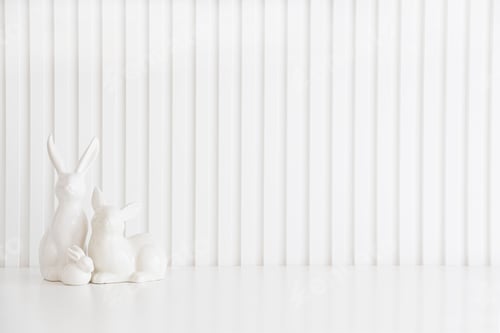 Preview: Easter rabbits figurines and eggs on white background.