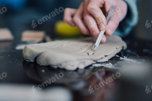 Preview: Ceramist using loop tool while working on clay slab