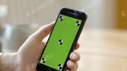 Preview: Close-up of woman holding phone with green screen. Stock footage. Beautiful female hand holding