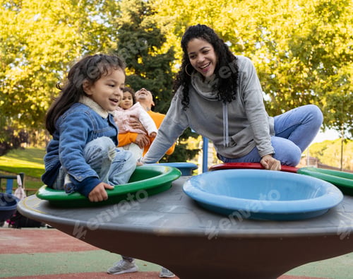 Preview: Happy latin family laughing and enjoying together in a playground.
