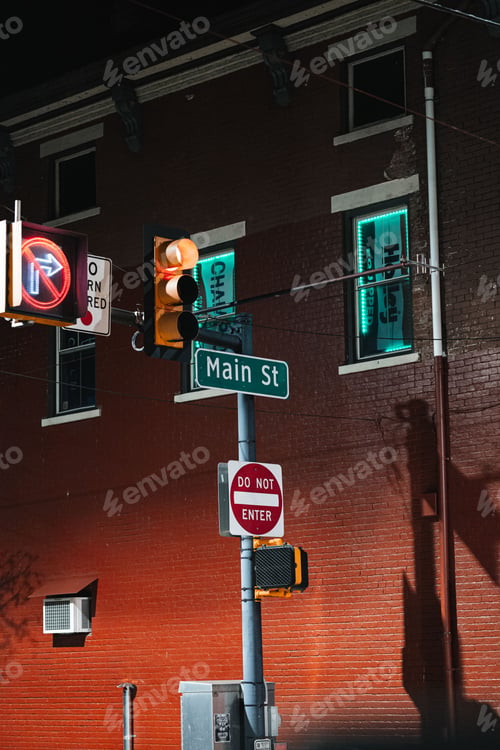 Preview: Vertical shot of a traffic light with different sign boards with a building in the background
