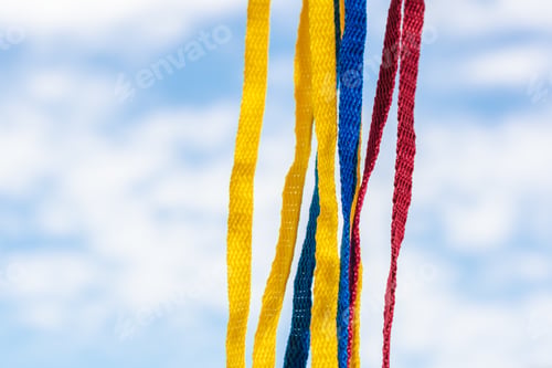 Preview: Flag of Colombia made with shoelaces, hanging on a background of the sky and clouds