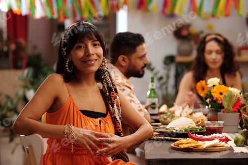 Preview: Young woman sitting by served table