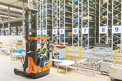Preview: Storehouse employee in uniform working on reachtruck in modern automatic warehouse.