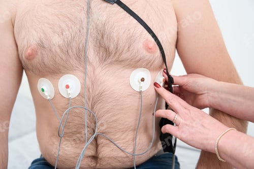Preview: Cropped photo of doctor sticking holter on male chest