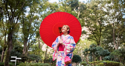 Preview: Park, umbrella and Japanese woman with fashion, sightseeing and urban travel with smile. Street, ki