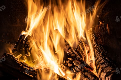 Preview: Fire orange tongues on black background in a brick fireplace
