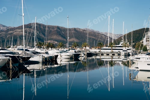 Preview: Sailing yachts stand in a row at the pier against the backdrop of mountains