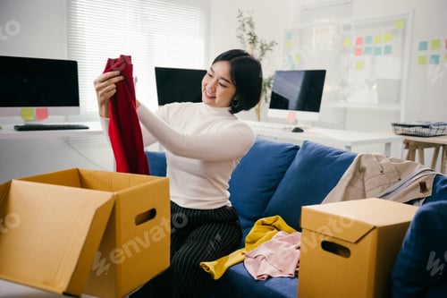 Preview: Startup employee packing clothes in cardboard box in office