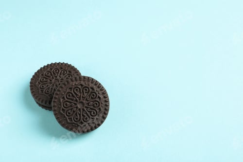 Preview: Tasty chocolate cookies with cream on color background, top view. Space for text