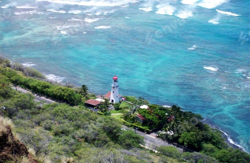 Preview: View of the blue ocean & beach border with a light house from the top of Diamond Head. Hawaii