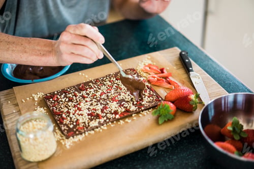 Preview: Close-up of woman making strawberry chocolate in kitchen at home