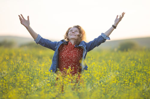 Preview: happy woman in beautiful yellow rapeseed field