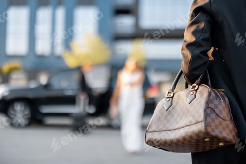 Preview: Businesswoman carries luxury handbag outdoors