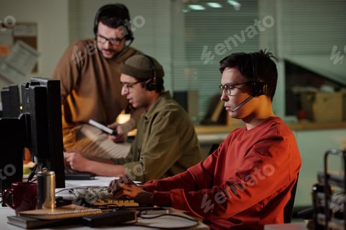 Preview: Young Adult Multiethnic Men Operating Computers in Scam Call Center at Night