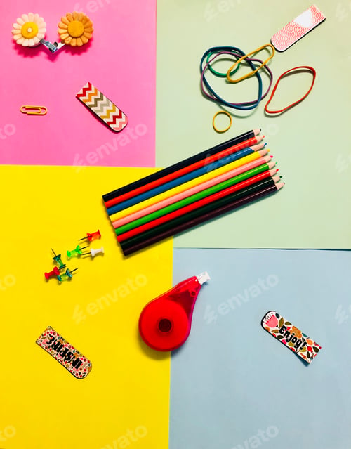 Preview: Flat lay of stationary items on a multicolored background.