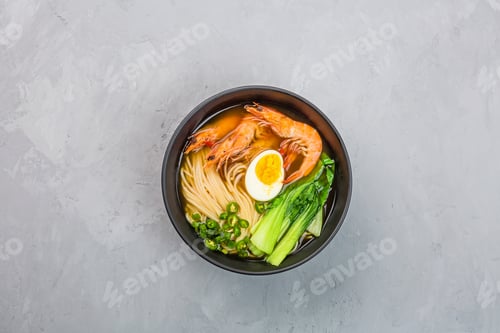 Preview: Asian noodle soup, ramen with prawn shrimp, vegetables and egg in black bowl on gray concrete