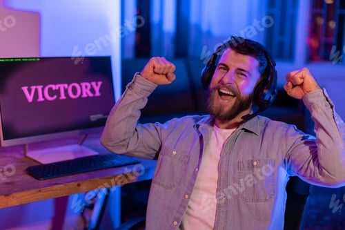 Preview: Joyous man gamer with victorious 'VICTORY' screen