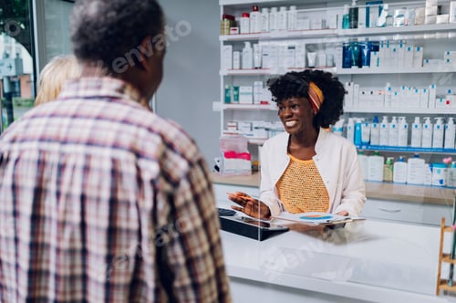 Preview: African american woman pharmacist selling drugs to a senior customer in a pharmacy