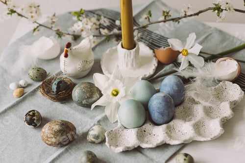 Preview: Stylish easter eggs in tray, cherry blossom and candle on rustic table. Happy Easter!