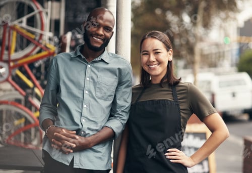 Preview: Shot of two young business owners standing outside their bicycle shop during the day