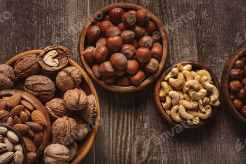Preview: top view of nuts in bowls arranged on wooden tabletop
