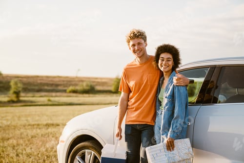 Preview: Multiracial couple smiling and hugging during car trip