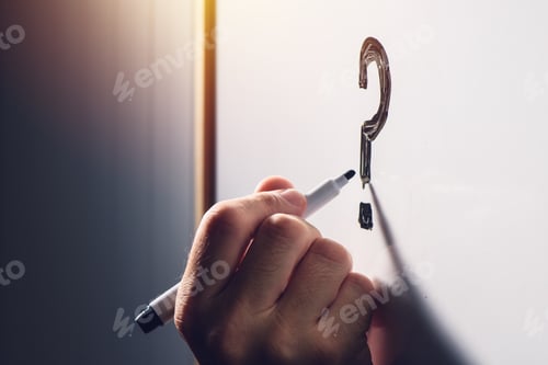 Preview: Confused businessman writing question mark on whiteboard