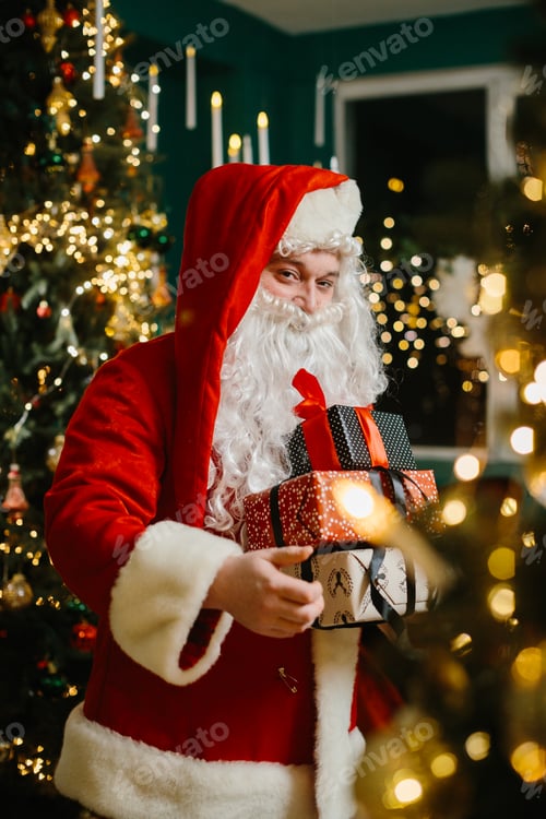 Preview: Santa claus holding christmas gifts near christmas tree