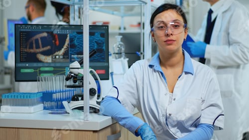 Preview: Portrait of scientist smiling at camera sitting in modern laboratory