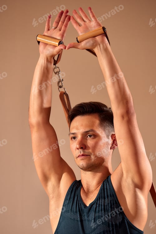 Preview: Pilates reformer workout exercises man at gym indoor.
