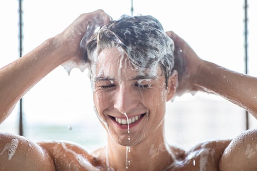 Preview: Handsome young male model washing hair with shampoo