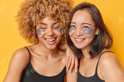Preview: Indoor close up of two young pretty happy smiling European and African american ladies standing