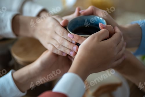 Preview: Family holding cup of tea in hands, warming in cold apartment