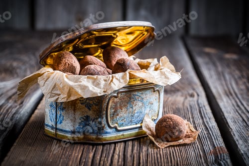Preview: Chocolate balls in golden box on wooden table