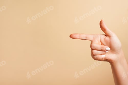 Preview: a forefinger pointing at a position, beige background with copy space
