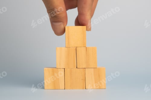 Preview: hand holding cube wood block blank on background. copy space