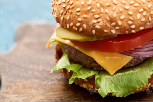 Preview: close up view of delicious cheeseburger on wooden board