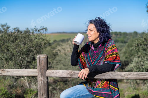 Preview: Mature woman enjoying drink outdoors feeling freedom