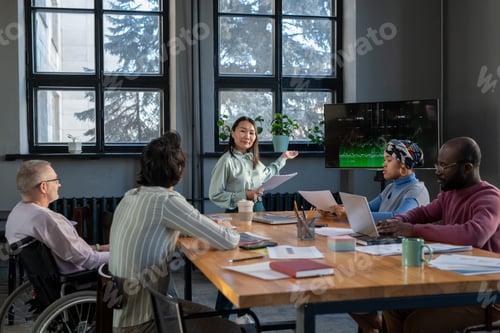 Preview: Young Asian businesswoman pointing at interactive screen with graph